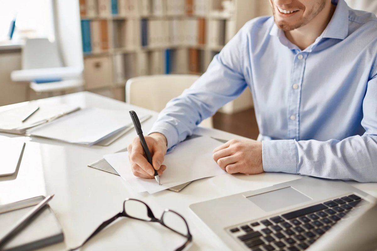 Man writing in a notebook at a desk