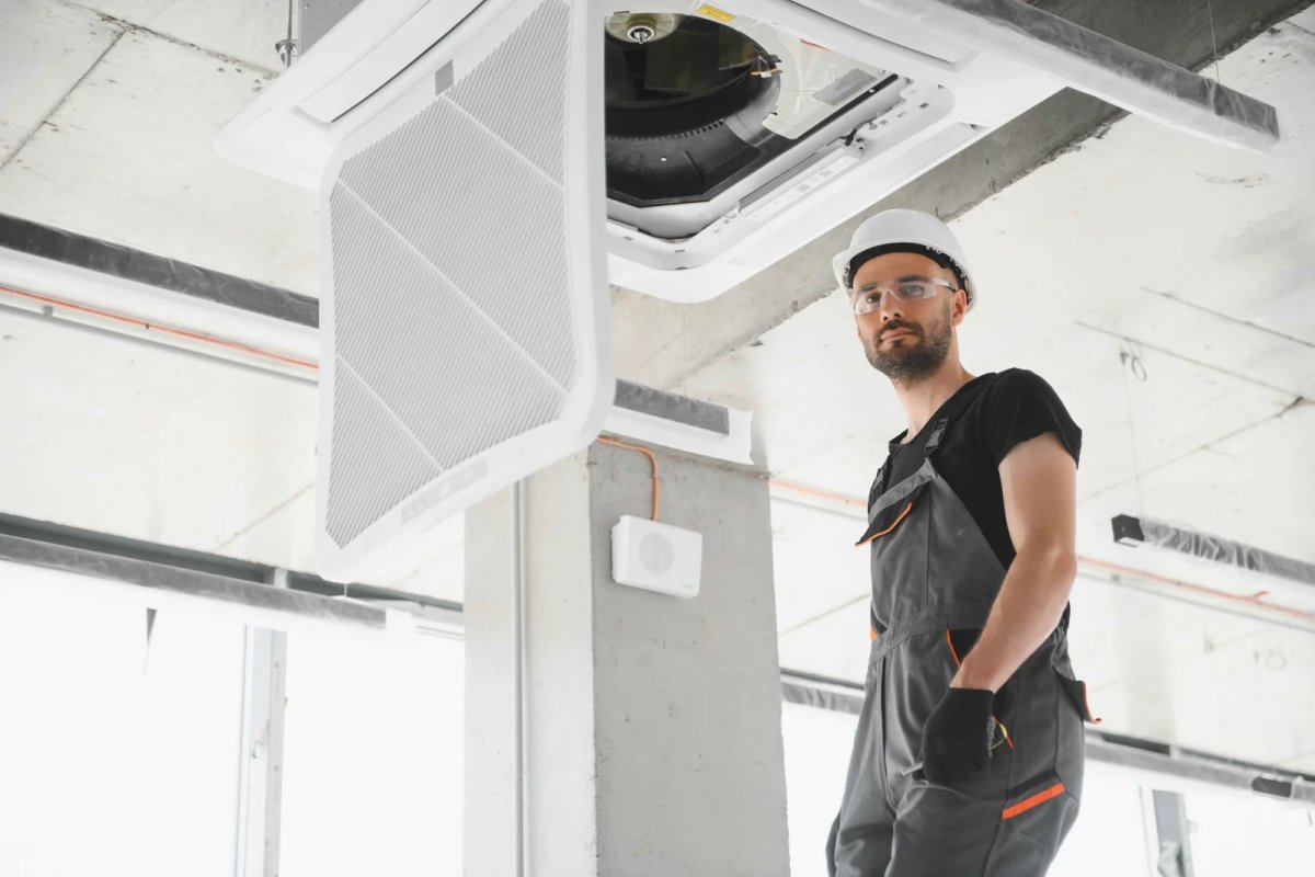 Technician inspecting ceiling AC unit