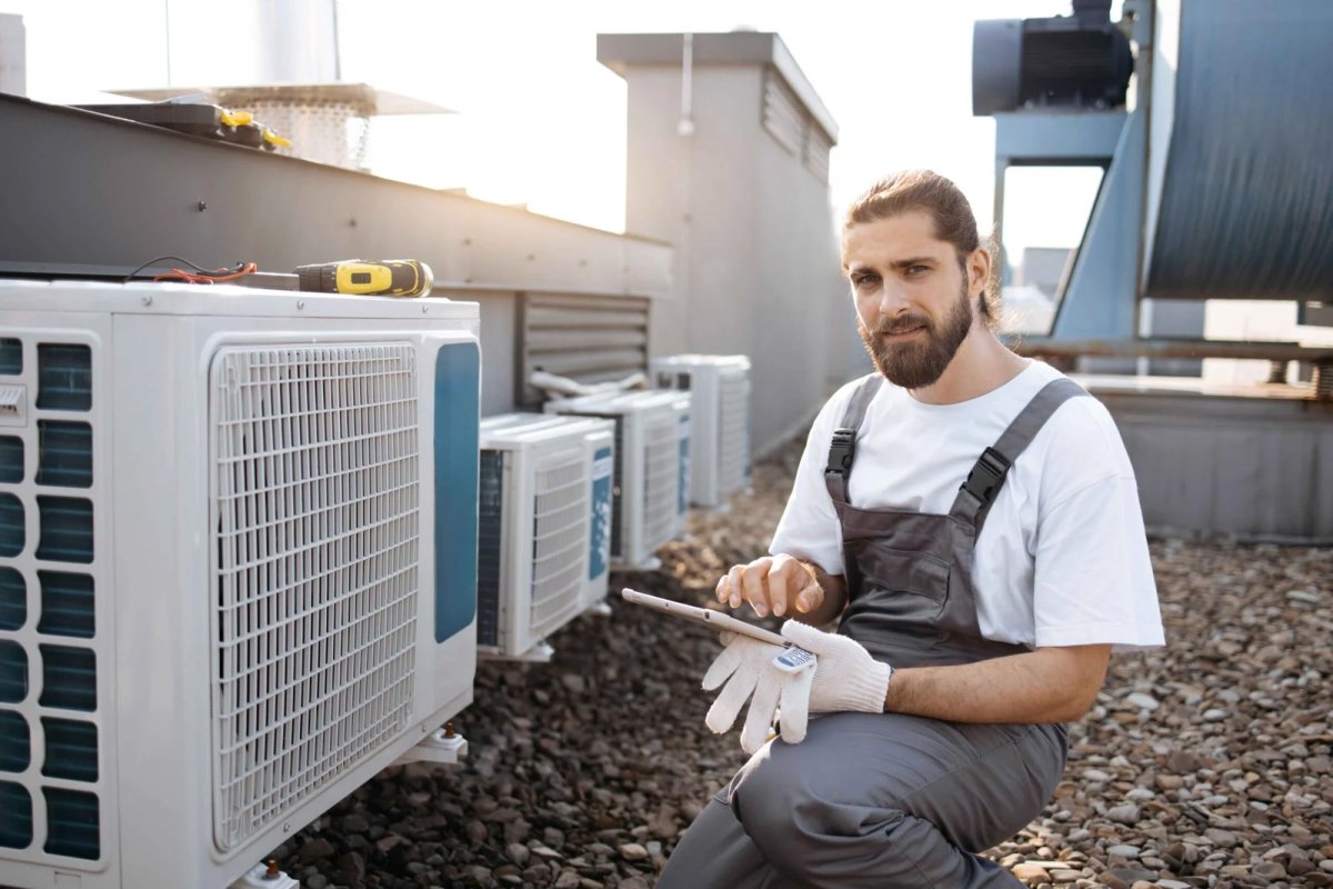 Man with tablet near AC units