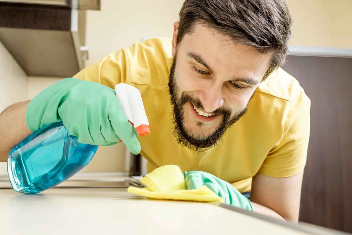 Male janitor cleaning kitchen with sponge Deep Cleaning