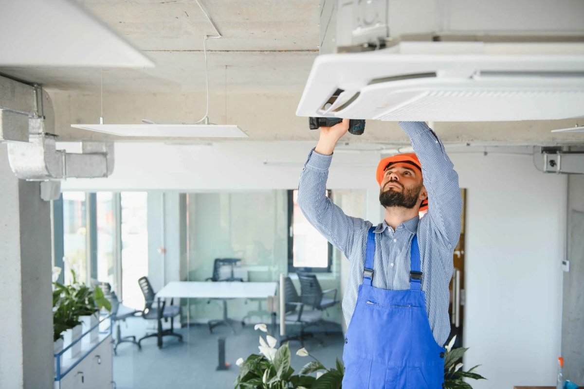 Technician inspecting an indoor AC unit
