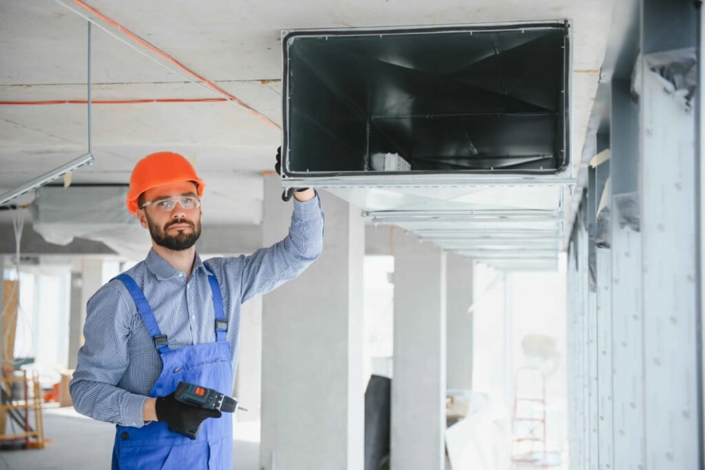 Worker installs ventilation duct